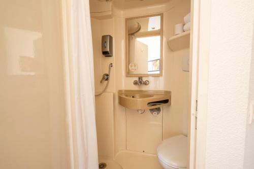 a bathroom with a sink and a toilet at Premiere Classe Roissy Aéroport Charles De Gaulle in Roissy-en-France