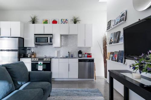 a living room with a couch and a kitchen at Modern, Dog Friendly Apartment with a Private Patio in Dallas