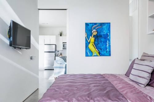 a bedroom with a bed and a painting on the wall at Modern, Dog Friendly Apartment with a Private Patio in Dallas