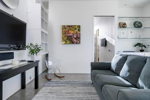 a living room with a couch and a flat screen tv at Modern, Dog Friendly Apartment with a Private Patio in Dallas