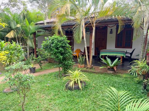 a house with palm trees and a yard at Green Lake Sigiriya in Sigiriya