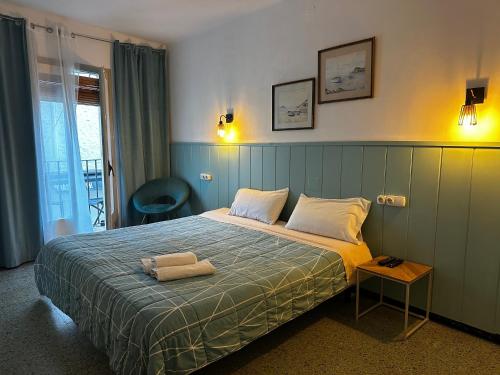 a bedroom with a bed in a room with a window at P&R hostals Maria Rosa in Tossa de Mar
