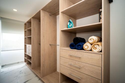 a walk in closet with wooden cabinets and a glass door at Barcelona Condos Cancun in Cancún