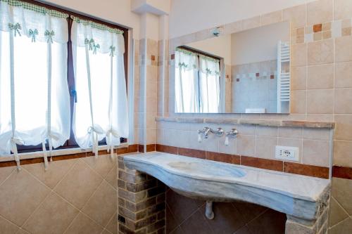 a bathroom with a sink and a mirror at Agriturismo Il Colle del Falco in Borghetto