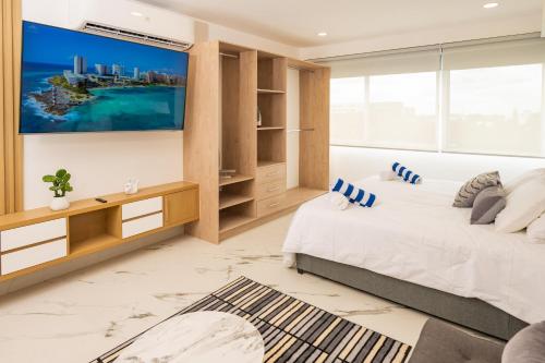 a bedroom with a bed and a tv on the wall at Barcelona Condos Cancun in Cancún