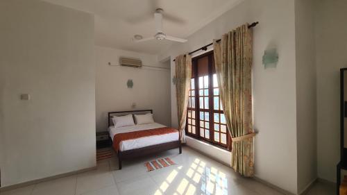 a bedroom with a bed and a window at Oceanway Residences in Wattala
