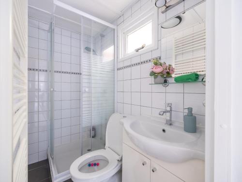 a white bathroom with a toilet and a sink at Ermway Cottage in Erm