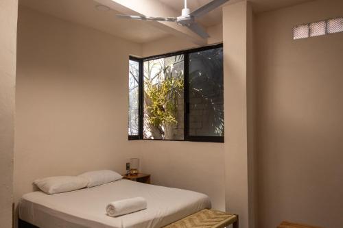 a bedroom with two beds and a window at La Punta SurfHouse in Brisas de Zicatela