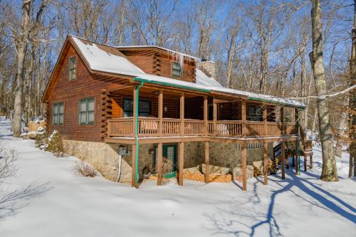 a log cabin in the woods in the snow at R & R Cabin by Railey Vacations in McHenry