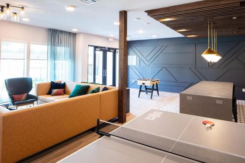 a living room with a couch and a table at Landing Beautiful Studio Gym Pool in Addison
