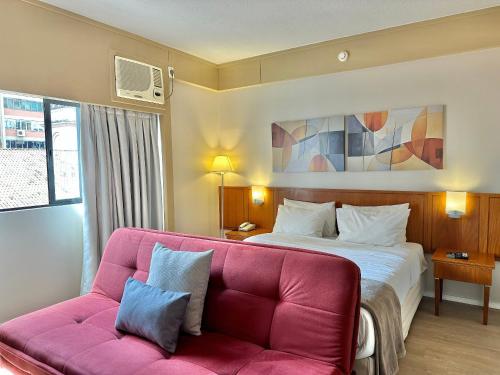 a hotel room with a bed and a couch at Flat Borges Lagoa com vaga de garagem, UH412 in São Paulo