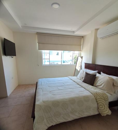 a bedroom with a large bed and a window at Casa completa con piscina privada en Manta, Ecuador in Manta