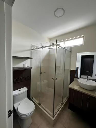 a bathroom with a shower and a toilet and a sink at Casa completa con piscina privada en Manta, Ecuador in Manta