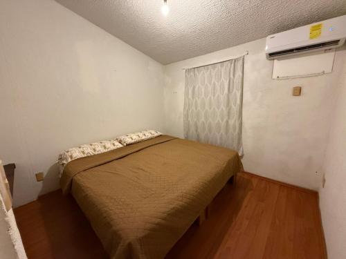a small bedroom with a bed in a room at Refugio de mar y arena in Acapulco