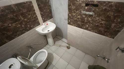 a bathroom with a toilet and a sink at The Casa Bella in Faridabad