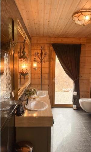 a bathroom with two sinks and a mirror at Rezidencia Woodchalet in Veľká Lomnica