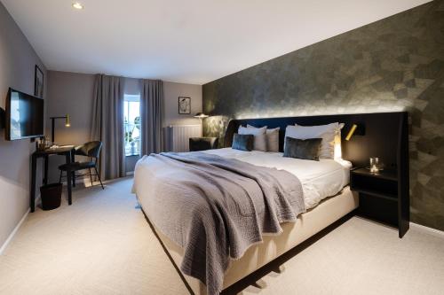 a bedroom with a large bed and a desk at Manoir Kasselslay in Roder