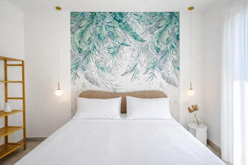 a bedroom with a large white bed with a wall mural at TerrAmare Suites in Baronissi