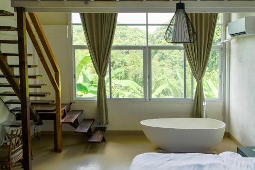 a bathroom with a large tub in front of a window at Utopia Hostel in Ngermid