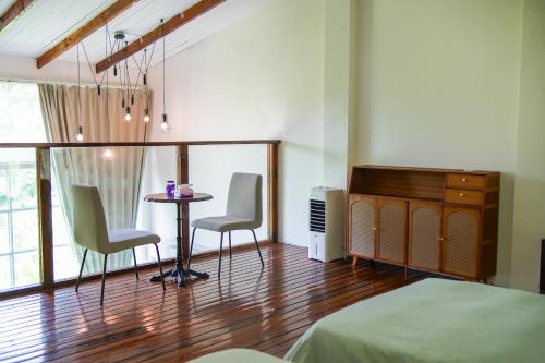 a bedroom with a table and two chairs and a bed at Utopia Hostel in Ngermid