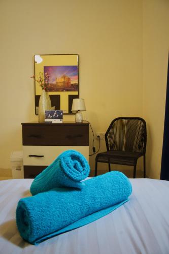 a blue towel laying on a bed with a dresser at 11 St Joseph in Birgu