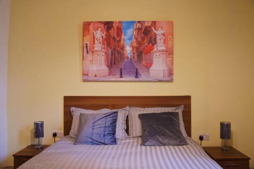 a bedroom with a bed with a painting on the wall at 11 St Joseph in Birgu