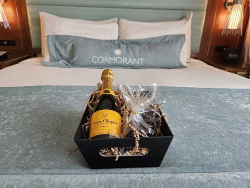 a bottle of champagne in a box on a bed at Cormorant Boutique Hotel in San Diego