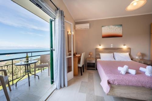 a bedroom with a bed and a balcony with the ocean at Pension Elena in Ágios Nikólaos