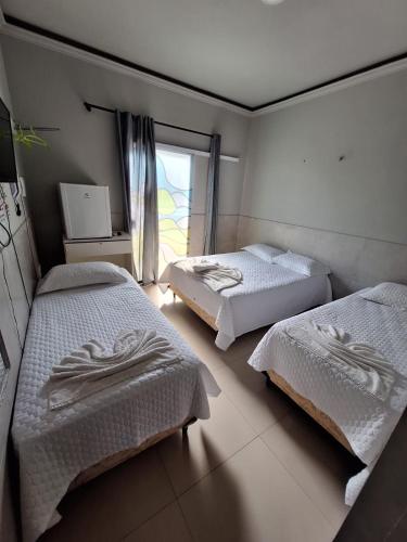 a bedroom with two beds and a window at Marcone Lima - Chalés in Barreirinhas