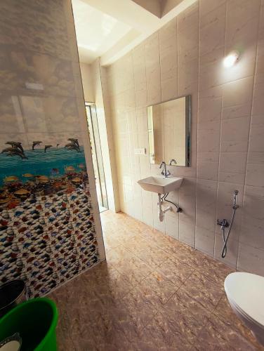 a bathroom with a sink and a wall with a bunch of logs at Ecoark Farmstay in Cuncolim