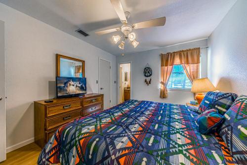 a bedroom with a bed and a dresser and a television at North Street Escape in Ruidoso