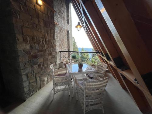 a patio with a table and chairs and a window at Alpine Home By HespakBNB in Dunga Gali