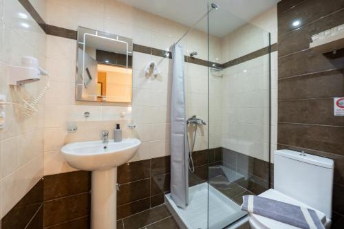 a bathroom with a sink and a shower and a toilet at Pension Elena in Ágios Nikólaos