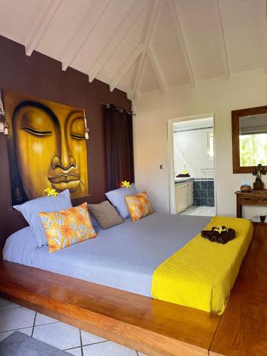 a bedroom with a large bed with a face painted on the wall at Résidence Adam et Eve in Orient Bay