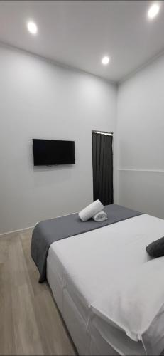 a bedroom with a large white bed and a flat screen tv at Renova7io sweet home Napoli in Naples