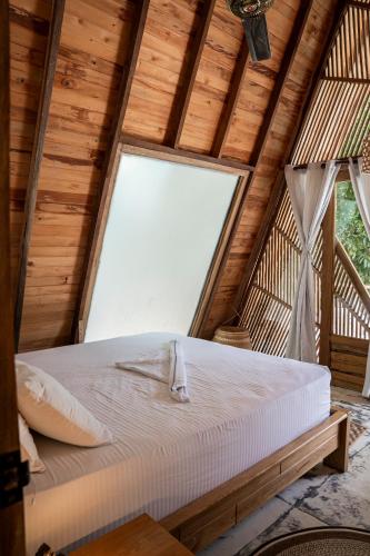 a bed in a room with a large window at Sambe Manglar in Moñitos