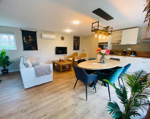 a kitchen and living room with a table and chairs at Morning Glory Huisje Jasmijn in Beekbergen