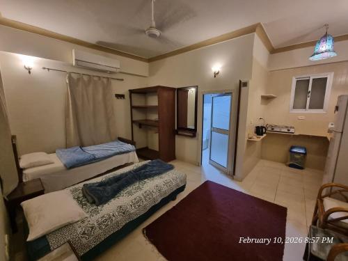 a bedroom with two beds and a room with a window at Kabeel's House in Dahab