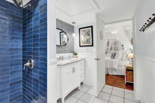 a bathroom with a sink and a blue tiled wall at Haint & Porcelain in Savannah
