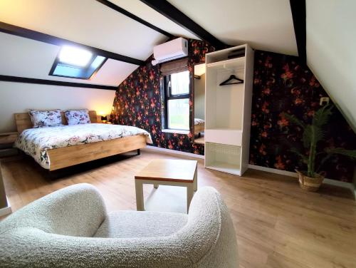 a bedroom with a bed and a couch and a chair at Morning Glory Huisje Salvia in Beekbergen