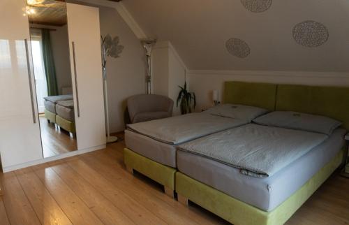 a bedroom with a bed and a chair in it at Frühstückspension-Appartement Liebmann in Schamberg