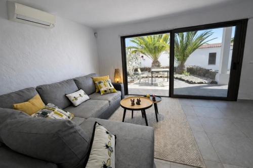 a living room with a gray couch and a table at Villa Sotavento Modern new apartment in Park Natural Adults Only in Playa Jandia