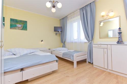 a bedroom with two beds and a mirror at Willa Irena in Karwia