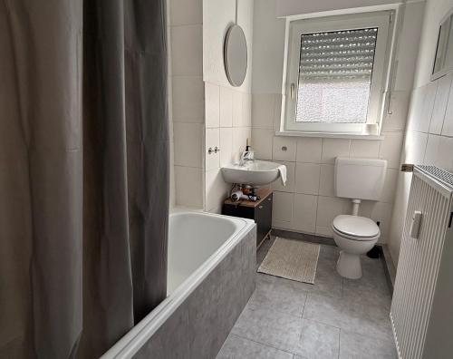 a bathroom with a tub and a toilet and a sink at Ferienwohnungen Uhrturm in Oppenheim