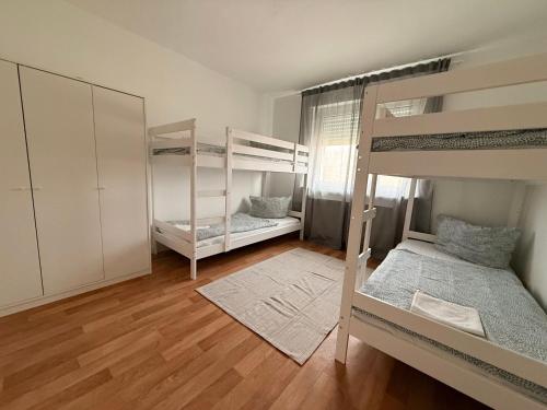 a bedroom with two bunk beds and a wooden floor at Ferienwohnungen Uhrturm in Oppenheim