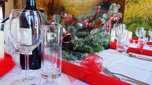 a table with wine glasses and a christmas tree on it at Hotel Górski Raj in Koninki