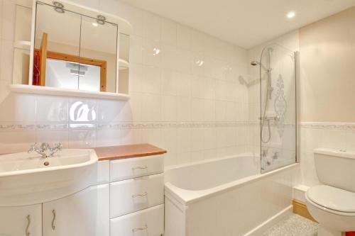a white bathroom with a sink and a tub and a toilet at 2 Bed in Cowling oc-ds238 in Cowling
