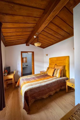 a bedroom with a large bed and a wooden ceiling at Casa do Olival in Macedo de Cavaleiros