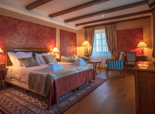 a hotel room with a bed and a table and chairs at Jurjevec Castle in Brežane Lekeničke