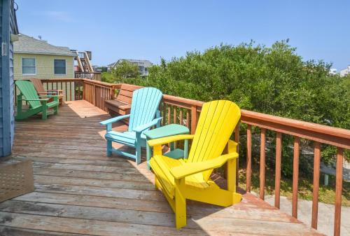 two colorful chairs sitting on a wooden deck at Misty Blue - Corolla, Ocean Sands, 200 Yards to Beach, Ocean View, Pets OK, Flex Stays Year Rnd in Corolla